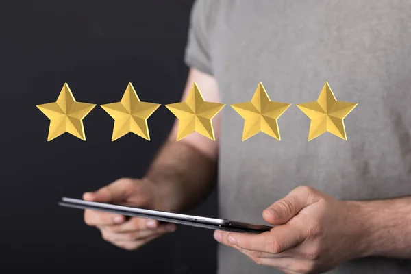 A 3d rendering of a review icon and rating stars showing a feedback above a tablet in person\'s hands