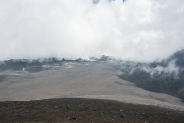 The white clouds floating above the grayish vale. Sicily, Italy.
