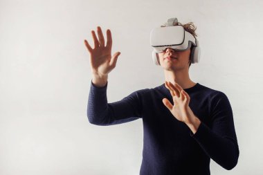 A young man exploring new universe with VR glasses