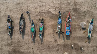 Kumlu bir sahildeki kanoların manzarası.