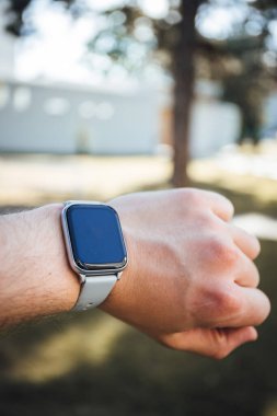 A vertical shot of a smart watch on a person's hand