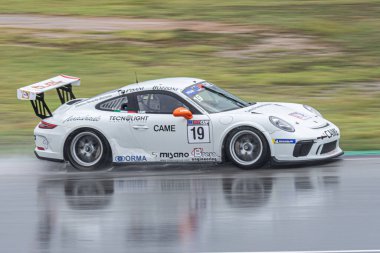 Islak pistte yarış arabası, yağmurlu bir günde. Porsche 911 Kupa 2018