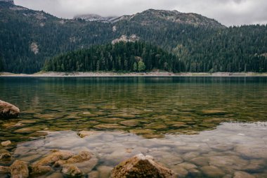 Gölün güzel manzarası ve yeşil bitki örtüsüyle kaplı tepeler. Karadağ 'da yürüyüş.