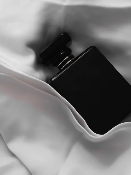 Tiro Vertical Uma Luxuosa Garrafa Perfume Preto Encontra Pano Branco — Fotografia de Stock
