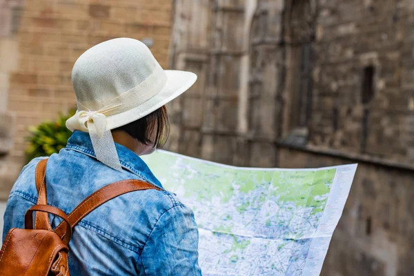 バルセロナ スペイン のゴシック地区に軽い帽子をかぶった地図を身に着けている観光客の後部ビュー 旅行コンセプト — ストック写真