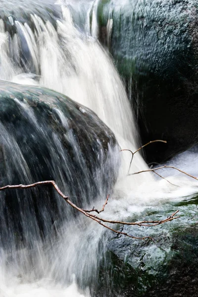 Vertical Shot Waterfall Flowing Big Boulders Thin Twigs Foreground — Foto de Stock