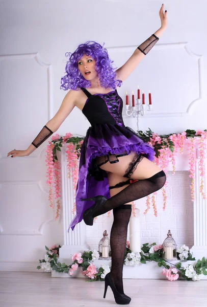 穿着复古迷你裙 穿着黑色长袜 长着紫色头发的长腿光头龙出现在壁炉前 — 图库照片