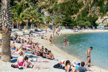 Hırvatistan 'ın Split kentindeki Marjan tepesindeki Jezinac plajında güneşlenen ve yüzen insanların güzel manzarası