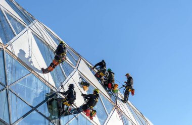 A group of professional window cleaners on a modern building in Budapest