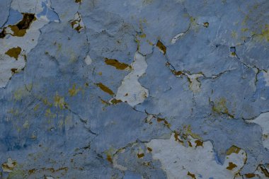 Çatlak ve boyalı eski mavi bir duvarın yakın çekimi.