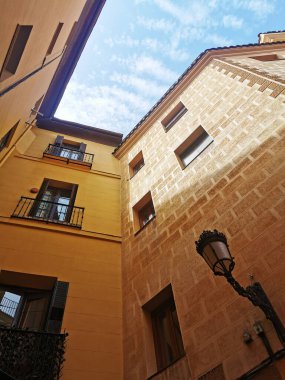 Madrid, İspanya 'daki yüksek sarı taş binaların dikey alçak açılı görüntüsü.