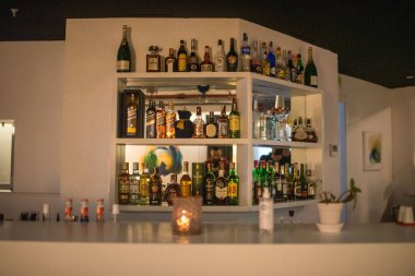 Restoran barının rafında farklı bir alkol şişesi var.