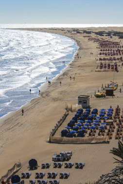A view of a populated beach with people swimming and walking on Canary Island, Spain