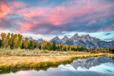 A bright sunset sky over the Three Tetons in Grand Teton, Wyoming