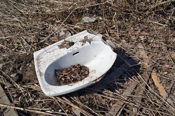 broken porcelain bathroom sink dumped in nature