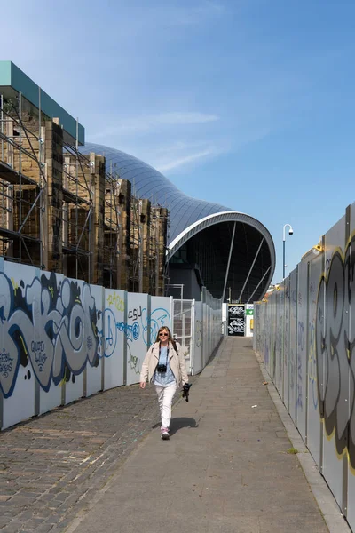 Woman Camera Tripod Walks Alleyway Construction Site Sage Gateshead Venue — Foto Stock
