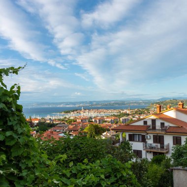 A high angle shot of buildings against a blue seascape in Izola, Slovenia