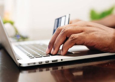 The male Hands holding credit card and using laptop. Online shopping