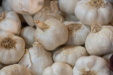 A closeup of a stack of fresh garlic in a market