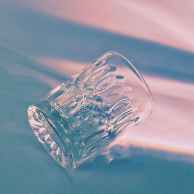 A closeup of a shadow from a glass on a white surface under natural sunlight