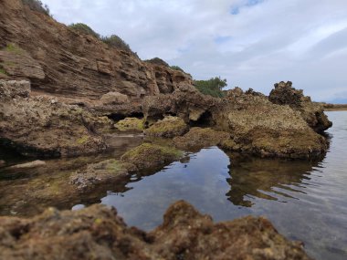 Bulutlu gökyüzünün altında gölde yansıması olan doğal kanyonların güzel bir manzarası.