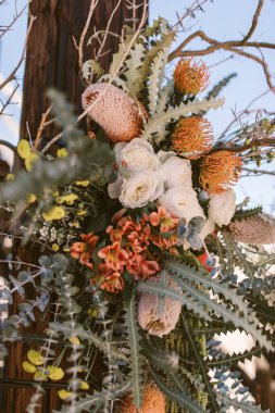 A vertical shot of a beautiful wedding flower decoration on a tree in California