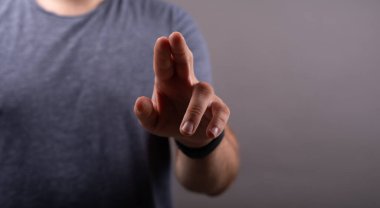 Gri arka planda bir insanın parmaklarının yakın çekimi.