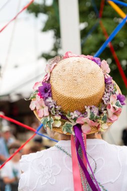 Renkli şapkalı geleneksel bir İngiliz Maypole dansçısının dikey çekimi.