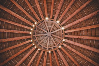 A view of a wooden dome with light bulbs from the inside