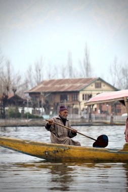 Kashmiri Shikara 'nın portresi. Dal Gölü' ndeki Hintli denizci. Hareket yüzünden eller bulanıklaşabilir..