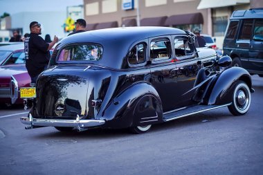 A back shot of a black Chevrolet Master Deluxe at the Sunday cruise in the street in El Paso, USA
