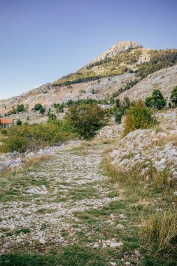 A vertical view of mountains and a blue sky in the background in Montenegro
