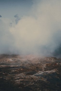 A vertical shot of fog in the mountains in daylight