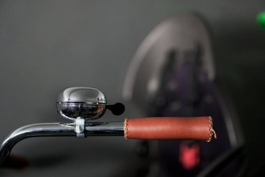 Bulanık bir arkaplanda gümüş bir bisiklet çanının yakın plan çekimi.