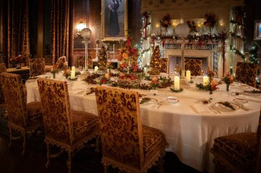 A beautiful interior shot of decorations and candles on a table with decorated chairs in Asheville, North Carolina during Christmas Holidays
