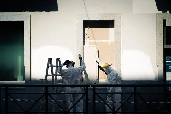 Closeup Two Workers Wearing White Suits Standing Building Facade Sunlight — Stok fotoğraf