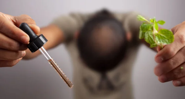 Een Man Zijn Hoofd Met Een Minoxidil Olie Druppelaar Muntblaadjes — Stockfoto