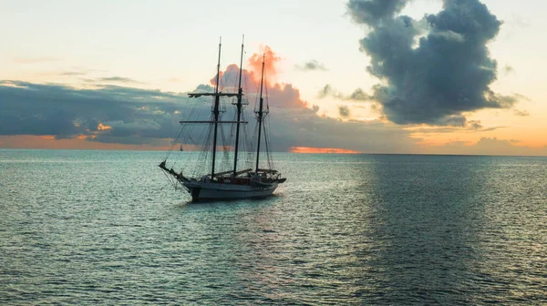 A large sailing pirate ship on a sea at sunset