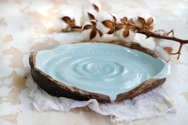 Beyaz bir masa yüzeyinde kurutulmuş pamukla eski seramik mutfak eşyalarının yakın çekimi.