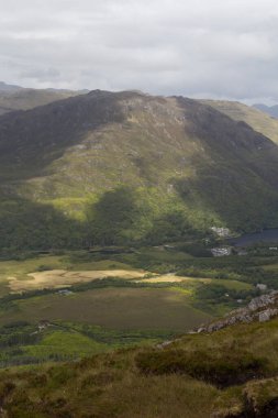 Bulutların altındaki vahşi bir İrlanda sahilinin dikey çekimi.