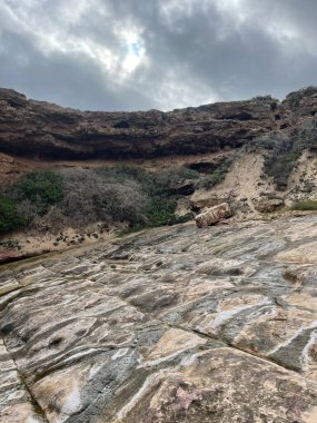 A vertical shot of a rocky cliff under a stormy sky in Horsham, Australia