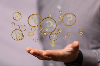 A hologram of a 3D rendered question marks with a person's hand below