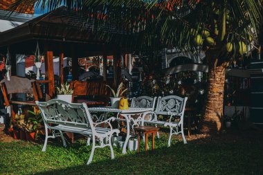 The outdoor cafe with white table and chairs on a sunny day