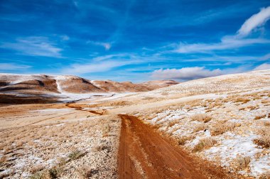 The Desert road covered with light snow, the black peak highest mountain in Lebanon.