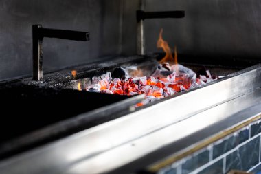 Yanan kömürleri olan barbekü fırını.