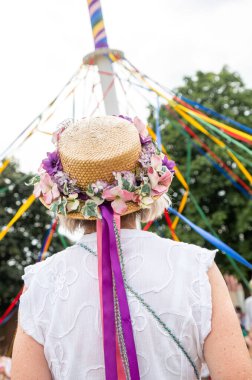 Renkli şapkalı geleneksel bir İngiliz Maypole dansçısının dikey çekimi.