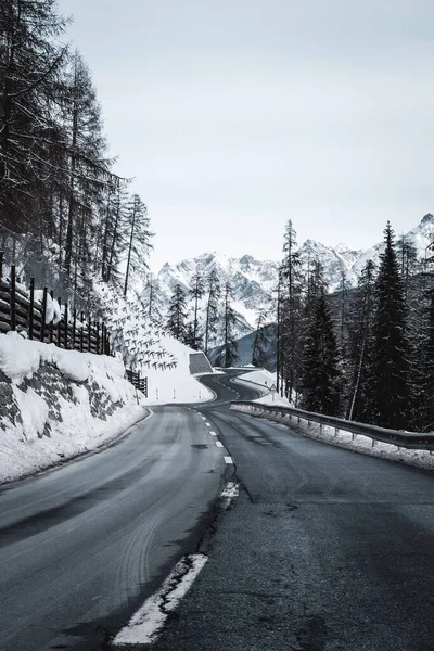 Μια Κάθετη Εικόνα Του Δρόμου Που Οδηγεί Στα Βουνά Χειμώνα — Φωτογραφία Αρχείου