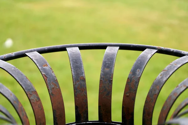 青みがかった背景に古い錆びた金属製のベンチのクローズアップ詳細 — ストック写真