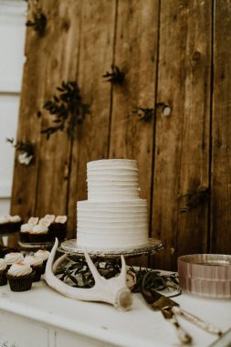 A closeup of a white wedding cake with decorations