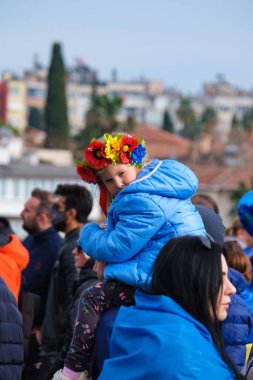 2022 'de Rusya' nın Ukrayna 'nın Cumhuriyet Meydani' deki işgalini protesto eden bir çocuk görülüyor